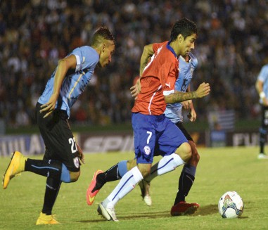 Mathías Suárez (i) y Gastón Faber (d) de Uruguay disputan el balón con Luciano Cabral (c) de Chile.EFE